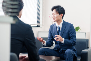 得意先と商談をするスーツを着たビジネスマン © maroke