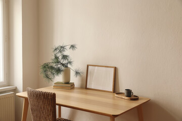 Christmas Scandinavian interior. Winter home decor. Blank horizontal wooden picture frame mockup, cup of coffee, tea. Table, rattan chair at window. Pine tree branches, vase. Wall background