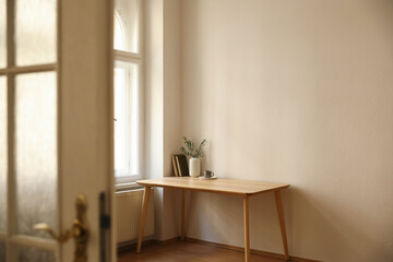 Living room view through blurred open white door. Vase with olive branches. Parquet floor. Home...