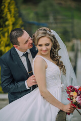A woman is getting ready for a wedding, and she is standing in front of a dresser with a wedding...