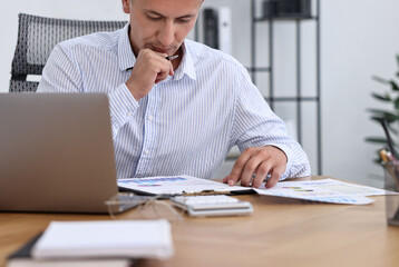 Obraz premium Banker working at wooden table in office