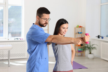 Fototapeta premium Patient exercising under physiotherapist supervision in rehabilitation center