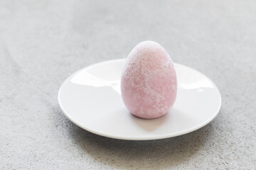 Raspberry ice cream in the shape of an egg. Close-up