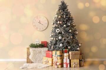 Christmas tree with presents and basket near light wall in room