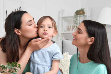Young lesbian couple with adopted little girl at home, closeup