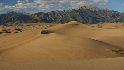 Person walking on large sand dunes at Great Sand Dunes National Park in Colorado, USA