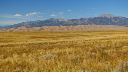 Large sand dunes of Great Sand Dunes National Park in front of mountains in Colorado, USA