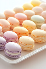 Fototapeta premium A tray of colorful pastel macarons beautifully arranged in neat rows, with flavors ranging from lavender to peach, creating a delightful and visually appealing presentation.
