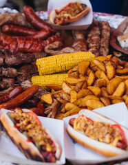 Food festival with food stall kiosk, open-air outdoor fair market, assortment of different traditional European grilled barbecued street food with sausages, bbq, chicken, pork and lamb on a large pan