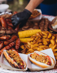Food festival with food stall kiosk, open-air outdoor fair market, assortment of different traditional European grilled barbecued street food with sausages, bbq, chicken, pork and lamb on a large pan