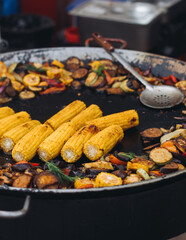 Food festival with food stall kiosk, open-air outdoor fair market, assortment of different traditional European grilled barbecued street food with sausages, bbq, chicken, pork and lamb on a large pan