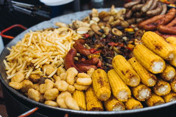 Food festival with food stall kiosk, open-air outdoor fair market, assortment of different traditional European grilled barbecued street food with sausages, bbq, chicken, pork and lamb on a large pan