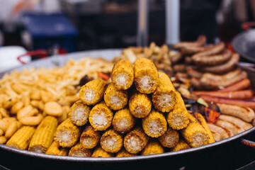Food festival with food stall kiosk, open-air outdoor fair market, assortment of different traditional European grilled barbecued street food with sausages, bbq, chicken, pork and lamb on a large pan
