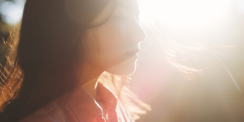 Soft, dreamy portrait of a young Asian woman in serene sunlight, her eyes closed in peaceful contemplation