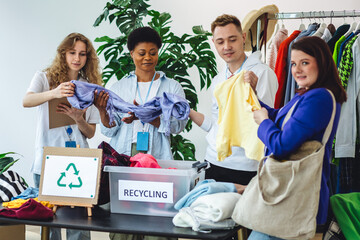 Young woman brings old clothes for recycling, charity, donation. Volunteers sorting textile to prevent pollution, environment protection. Second hand shopping. Eco conscious responsible lifestyle.