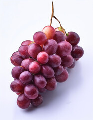 Fototapeta premium A bunch of purple grapes with one separate grain, focus on the skin texture isolated on white background