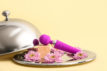 Tray with vibrator, flowers and cloche on color background