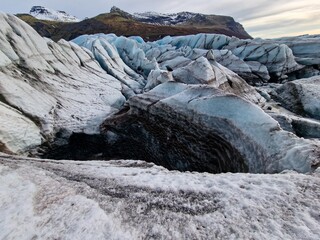 Frost covered Vatnajokull glacier cap in Iceland with massive cracked blue glaciers. Nordic hills...