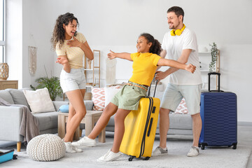 Happy family with packed suitcases for travel at home