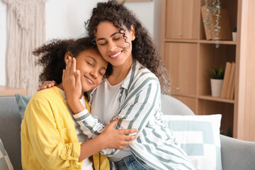 Obraz premium Young African-American woman with her daughter hugging at home
