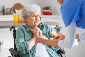 Young African-American female medical worker mistreating scared elderly woman in nursing home