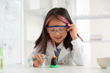 Cute little girl conducting chemistry experiment in science classroom