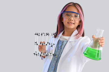 Cute little girl with chemistry flask and molecular model on grey background