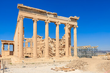 Obraz premium The ruins of a building with columns and a blue sky in the background, Acropolis in Athens