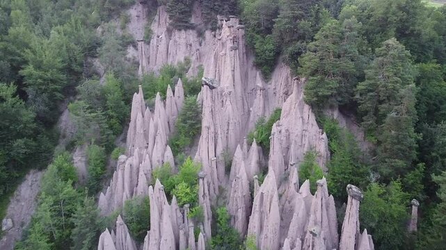 Earth pyramids rising from green forest in South Tyrol, Italy