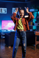 Lively child showcasing enchanting dance routine on social media platform, participating in online...