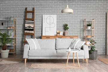 Interior of living room with wooden ladder, sofa and shelf units