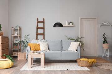 Interior of living room with wooden ladder, sofa and door