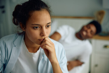 Pensive woman feeling worried after  argument with her boyfriend in bedroom.