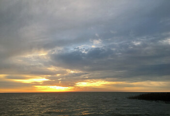 Obraz premium Autumn sunrise over the Curonian Lagoon. View of the bay from the resort town of Nida, Lithuania.