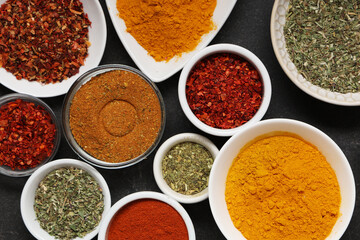 Composition with bowls of different aromatic spices on dark background