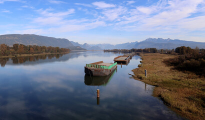 River full of  reflections of clouds and moored barges