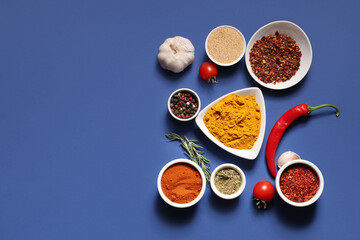 Composition with fresh aromatic spices and vegetables on blue background
