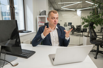 Caucasian deaf man talking sign language over video call on laptop in office.