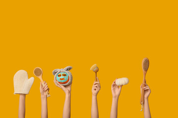 Women holding funny pumpkin with cosmetic mask, headband and spa accessories on yellow background