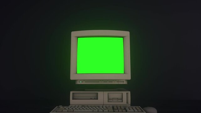 Old retro computer with green chroma key screen isolated on black background