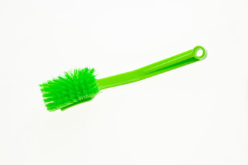 Plastic brush with green bristles for home cleaning.