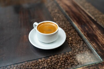 coffee cup at rustic cafe with interesting table filled with coffee beans
