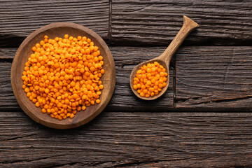 Red lentils in bowl and spoon - Lens culinaris organic.