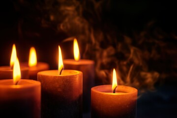 Burning candles on dark background create warm, intimate ambiance. Soft, golden light shines from multiple flames. Calm, peaceful atmosphere perfect for relaxation, meditation, or romantic evening.