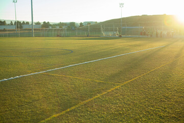 Artificial turf sports field in afternoon sunset, background
