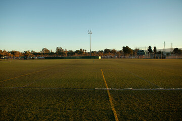 Artificial turf sports field in afternoon sunset, background