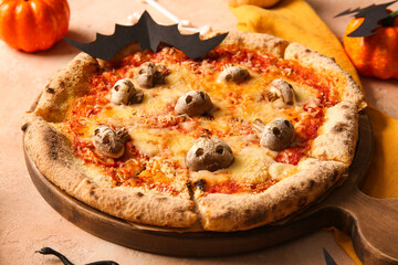 Tasty pizza with mushrooms and paper bat for Halloween celebration on beige background