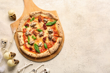 Wooden board of tasty pizza with mushrooms, bones, skulls and skeleton for Halloween celebration on white background