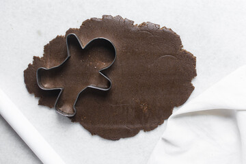 top view of gingerbread cookie dough, Overhead view of cut out molasses cookie dough on a marble countertop, process of making christmas cookies