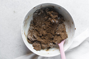 Overhead view of molasses cookie dough in a white mixing bowl, top view of gingerbread cookie dough, process of making christmas cookies